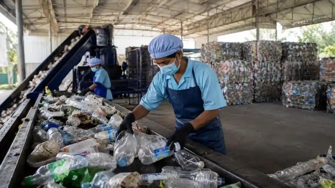 Fasilitas modern pengolahan dan daur ulang material dengan konsep ekonomi sirkular, memperlihatkan proses pemilahan bahan, penggunaan energi bersih, serta lingkungan industri hijau yang tertata rapi.